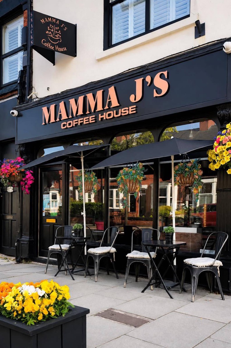 The Mamma J's shopfront on the High Street, covered in hanging baskets with tables outside
