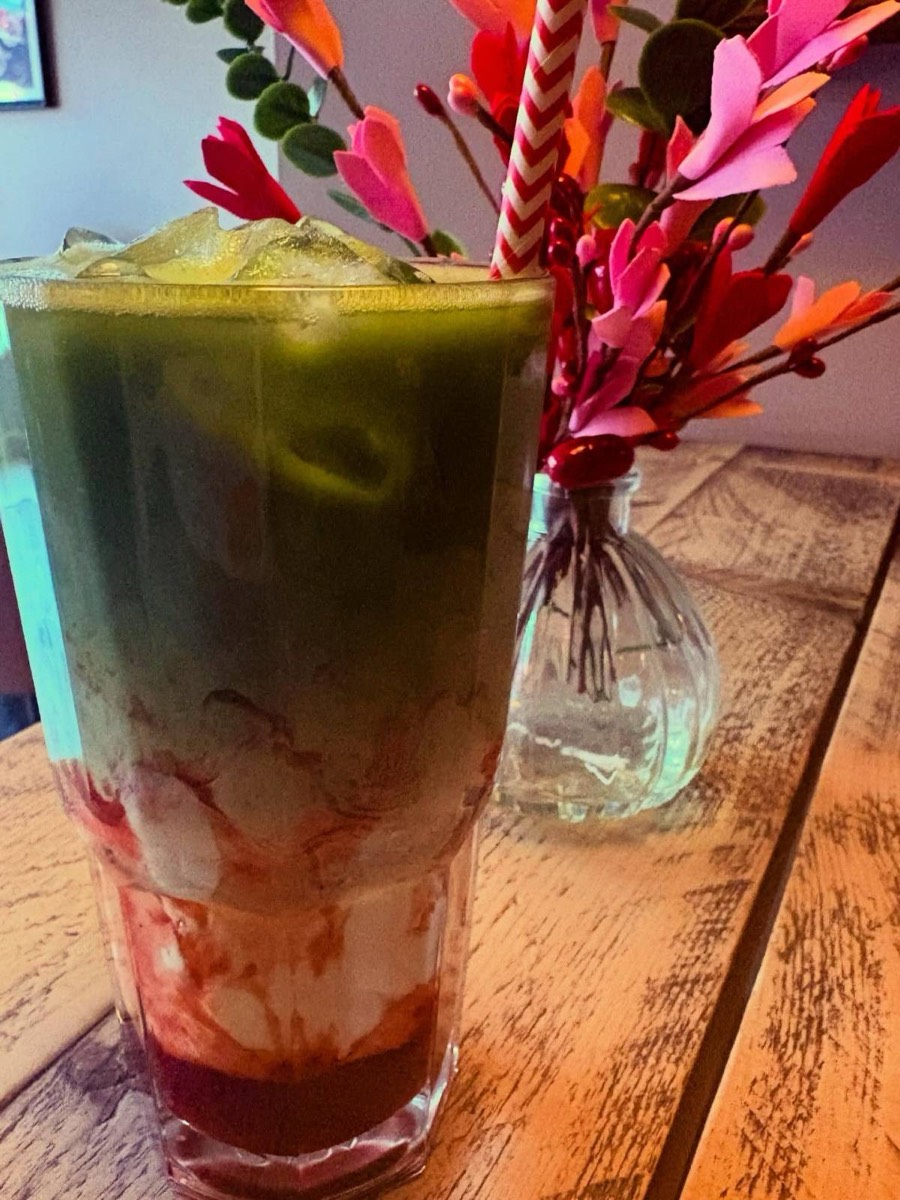 Layered iced matcha drink with a straw
